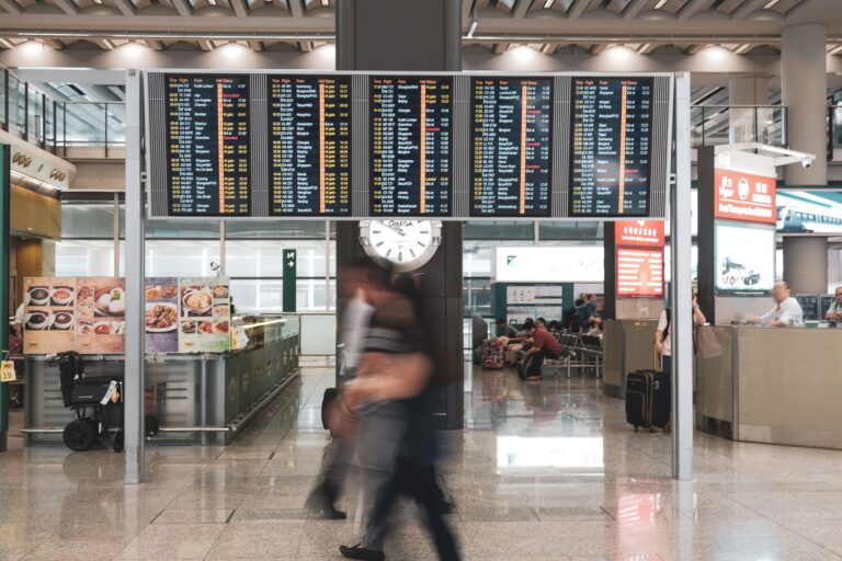Travelers moving through a modern airport terminal near security screening