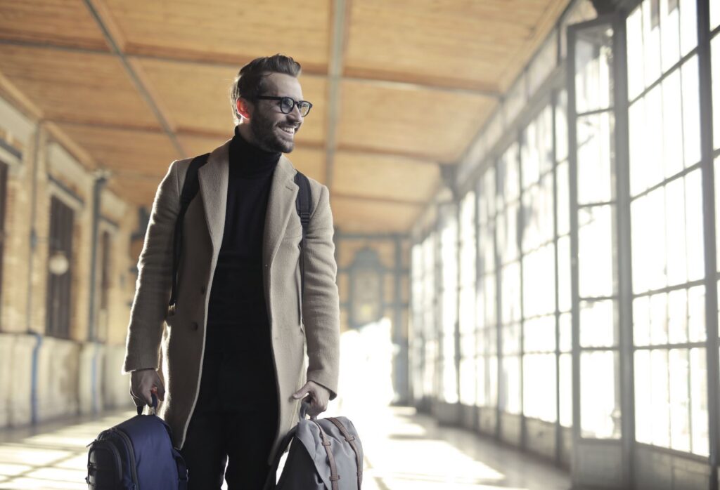 Traveler walking through an airport terminal corridor with checked bags