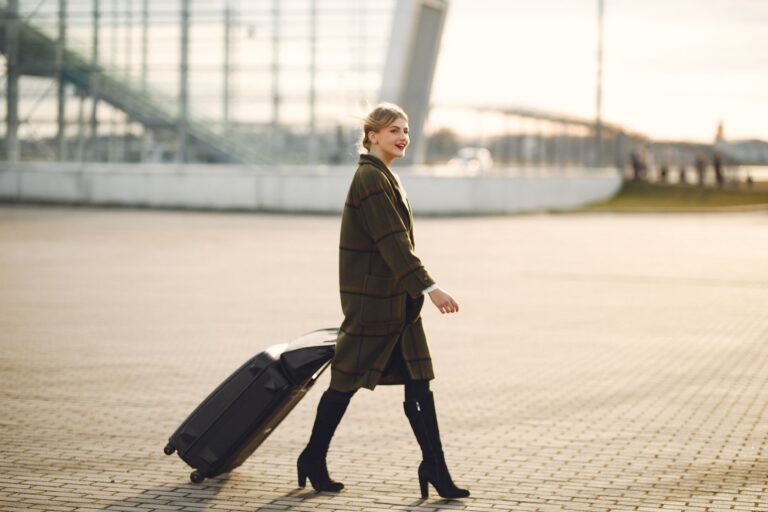 Traveler pulling a suitcase outside an airport terminal