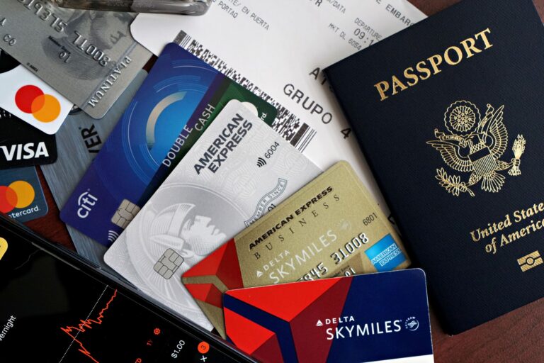 A collection of travel essentials including a passport, credit cards, and a boarding pass.