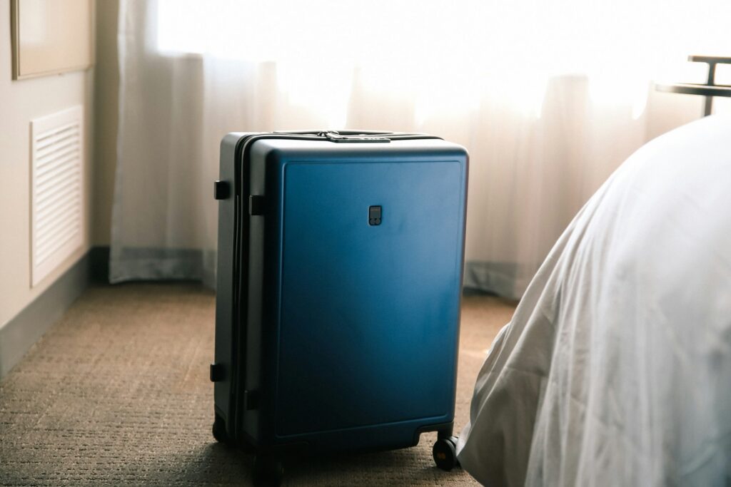 A packed blue suitcase in a hotel room, ready for a domestic flight that requires a REAL ID compliant identification document