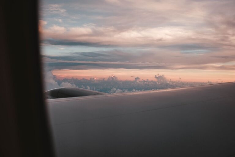 Sunset view from an airplane window over clouds, representing international travel and visa sponsorship
