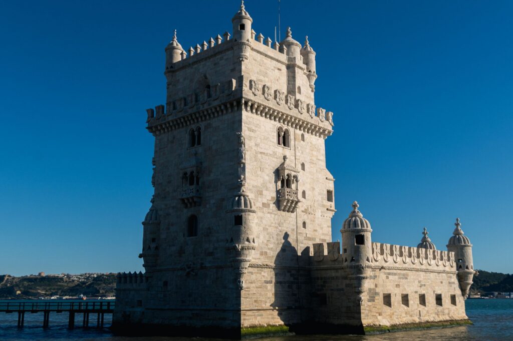 The Belém Tower standing in the Tagus river under a clear blue sky, day two of a three-day Lisbon itinerary