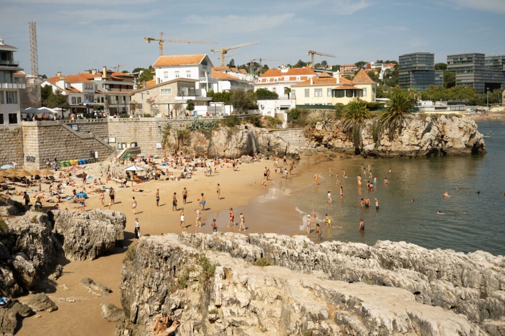 A town beach at Cascais below old villas and rocks, a 40-minute train day trip from Lisbon