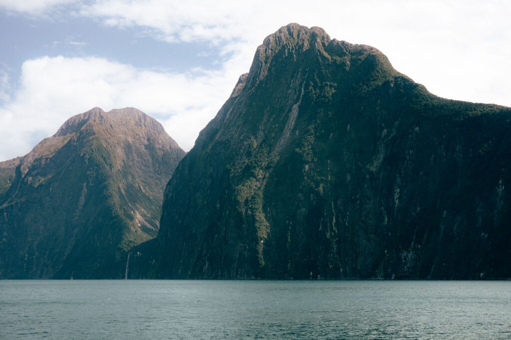 Steep cliffs rising out of Milford Sound, the longest day trip from Queenstown
